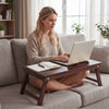 Adjustable bamboo laptop desk with tilting top and adjustable legs, perfect for working or dining on the couch.