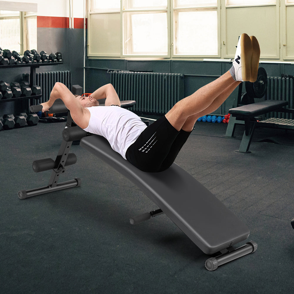 Adjustable decline sit-up bench with padded cushion, showcasing a user performing an exercise in a gym setting.