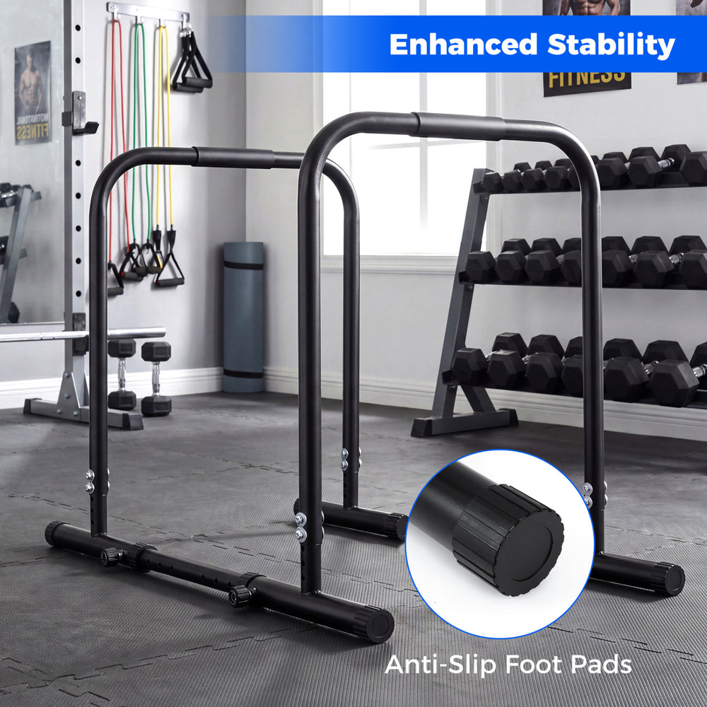 Adjustable dip bar station in black with foam-padded handles and non-slip foot pads, ideal for strength training.