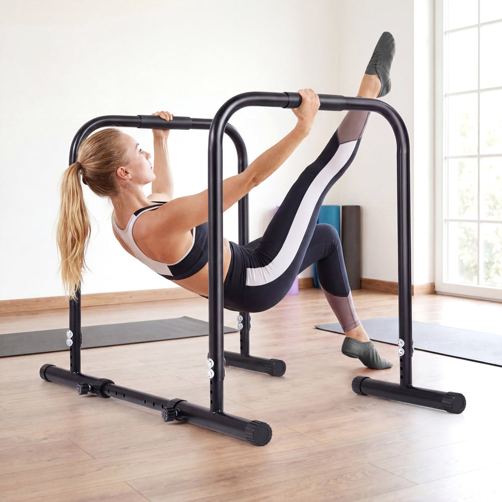 Adjustable dip bar station in black, featuring a heavy-duty frame and foam-padded handles for calisthenics workouts.