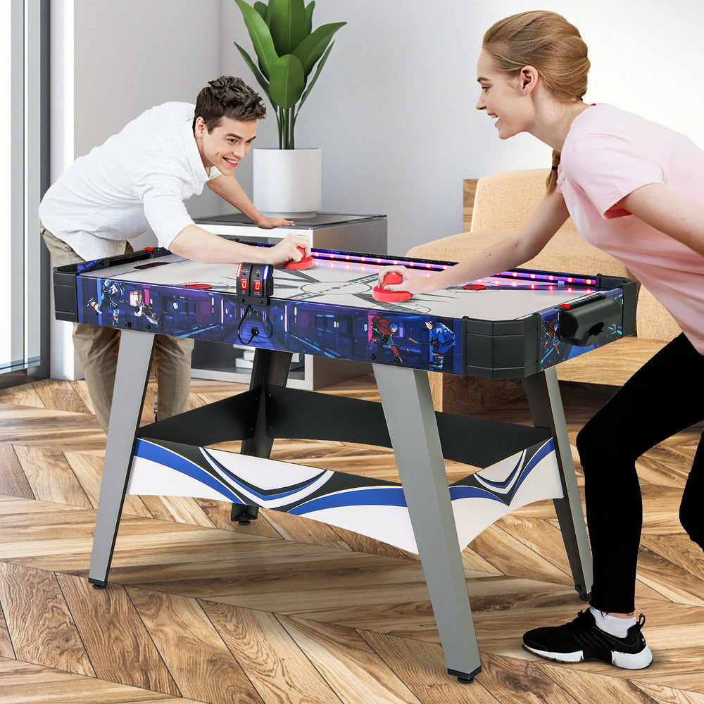 Air hockey game table in blue with LED score display, featuring two pushers and pucks for family fun and skill.