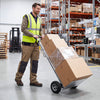 Aluminum dolly cart with ergonomic handle and dual rubber wheels, ideal for transporting boxes in a warehouse setting.