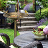 Antique gold freestanding pedestal bird bath feeder with vintage finish, attracting birds in a garden setting.
