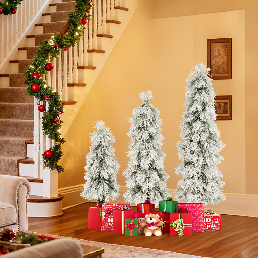 Three snow-flocked artificial Christmas trees with LED lights and presents, perfect for festive holiday decor.
