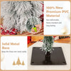 Snow-flocked branch tips of an artificial Christmas tree with a solid metal base, perfect for holiday decorations.