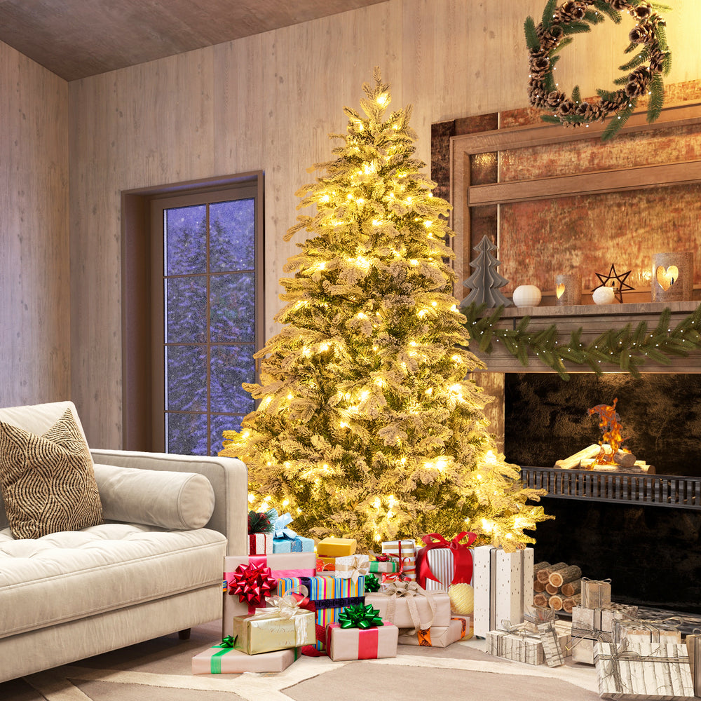 Flocked 6 ft Christmas tree with warm white LED lights, surrounded by colorful gifts in a cozy living room setting.