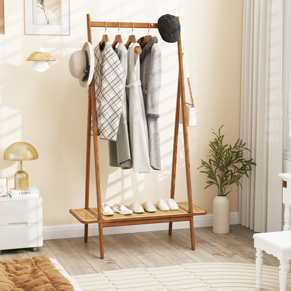 Bamboo clothes rack with hanging rod, rattan shelf, and copper hooks for organized storage in entryway or bedroom.