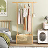 Bamboo clothes rack with hanging rod and rattan storage basket on wheels, perfect for bedroom organization.