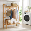 Bamboo clothing garment rack with a natural finish, featuring a hanging rod and two storage shelves for versatile organization.