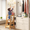 Bamboo kids kitchen step stool in use, helping a child reach for clothes, promoting independence and skill development.