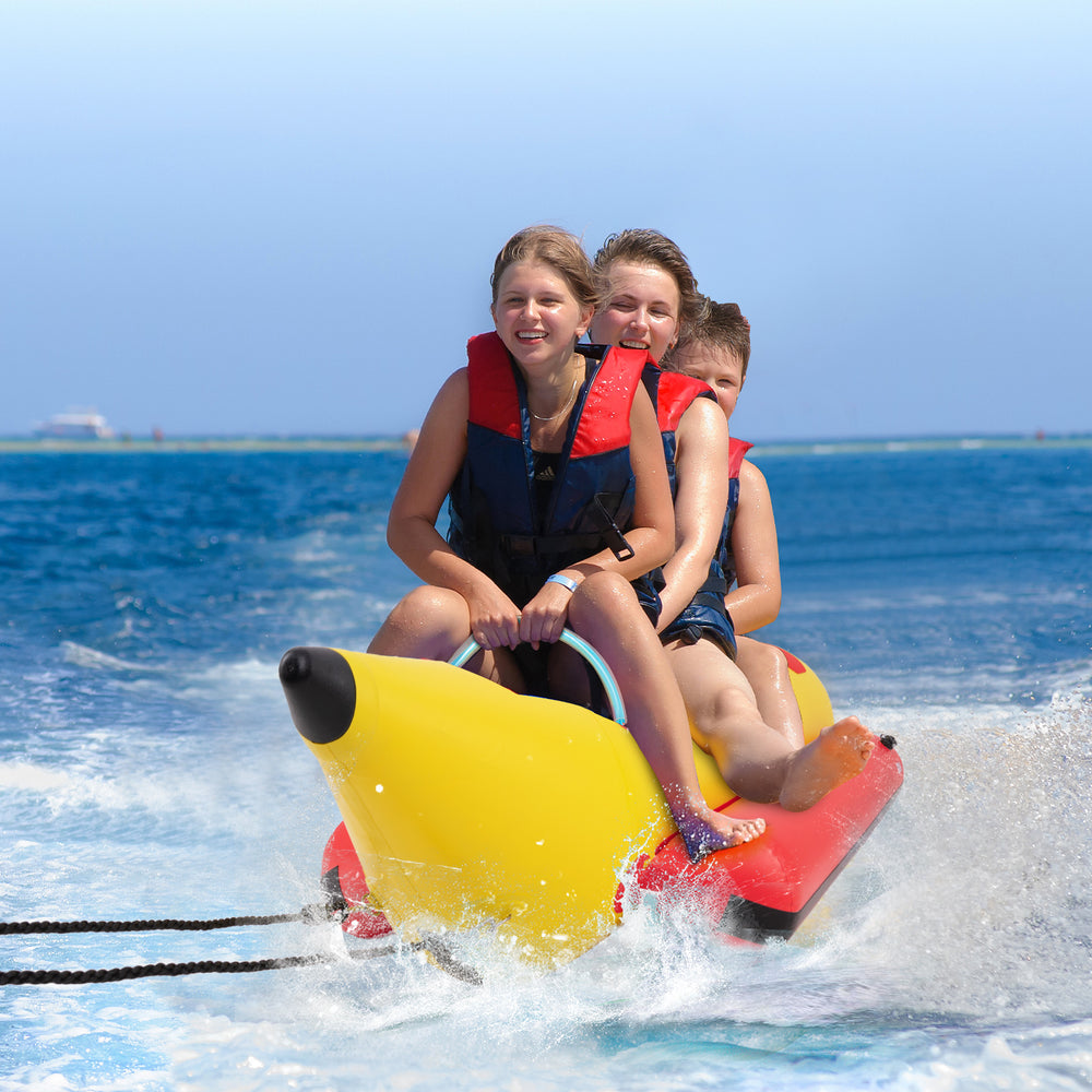 Three kids enjoying a ride on a bright yellow inflatable banana boat, designed for durability and safety on water.