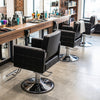 Black barber salon chair with hydraulic pump, adjustable height, and 360° swivel for comfortable styling sessions.