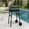 Barrel charcoal grill with foldable side table, built-in thermostat, and wheels for easy transport, ideal for backyard.