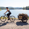 Heavy-duty bike cargo trailer in black, supporting up to 220 lbs, ideal for camping and shopping on all terrains.