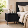 Black modern nightstand with a compact footprint, featuring an open shelf and stylish fluted design for elegant storage.