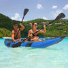 Two-person inflatable kayak in blue with aluminium oars, paddling on clear water, ideal for outdoor adventures.