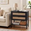 Boho rattan nightstand in black with two drawers and an open shelf, perfect for versatile storage beside a sofa.