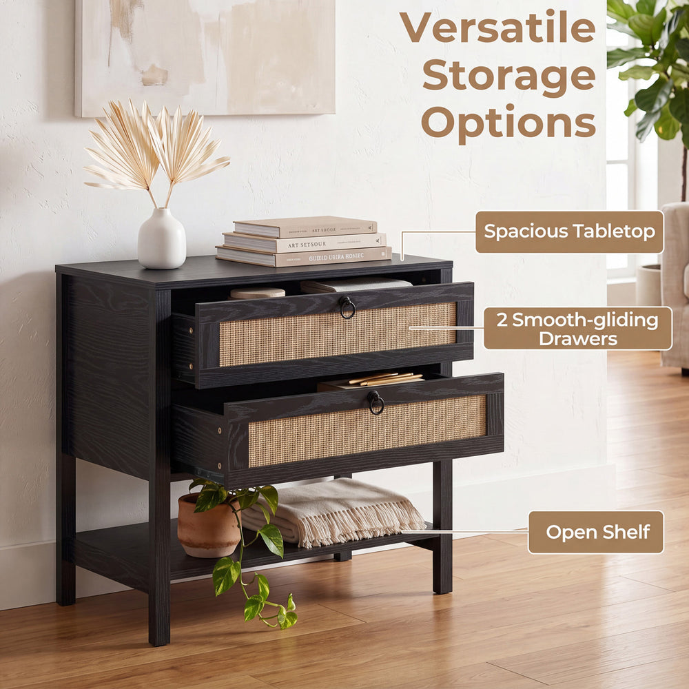 Boho rattan nightstand in black featuring two drawers, an open shelf, and a spacious tabletop for versatile storage.