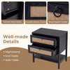 Boho rattan nightstand in black featuring two drawers, open shelf, and smooth metal slides for versatile storage.