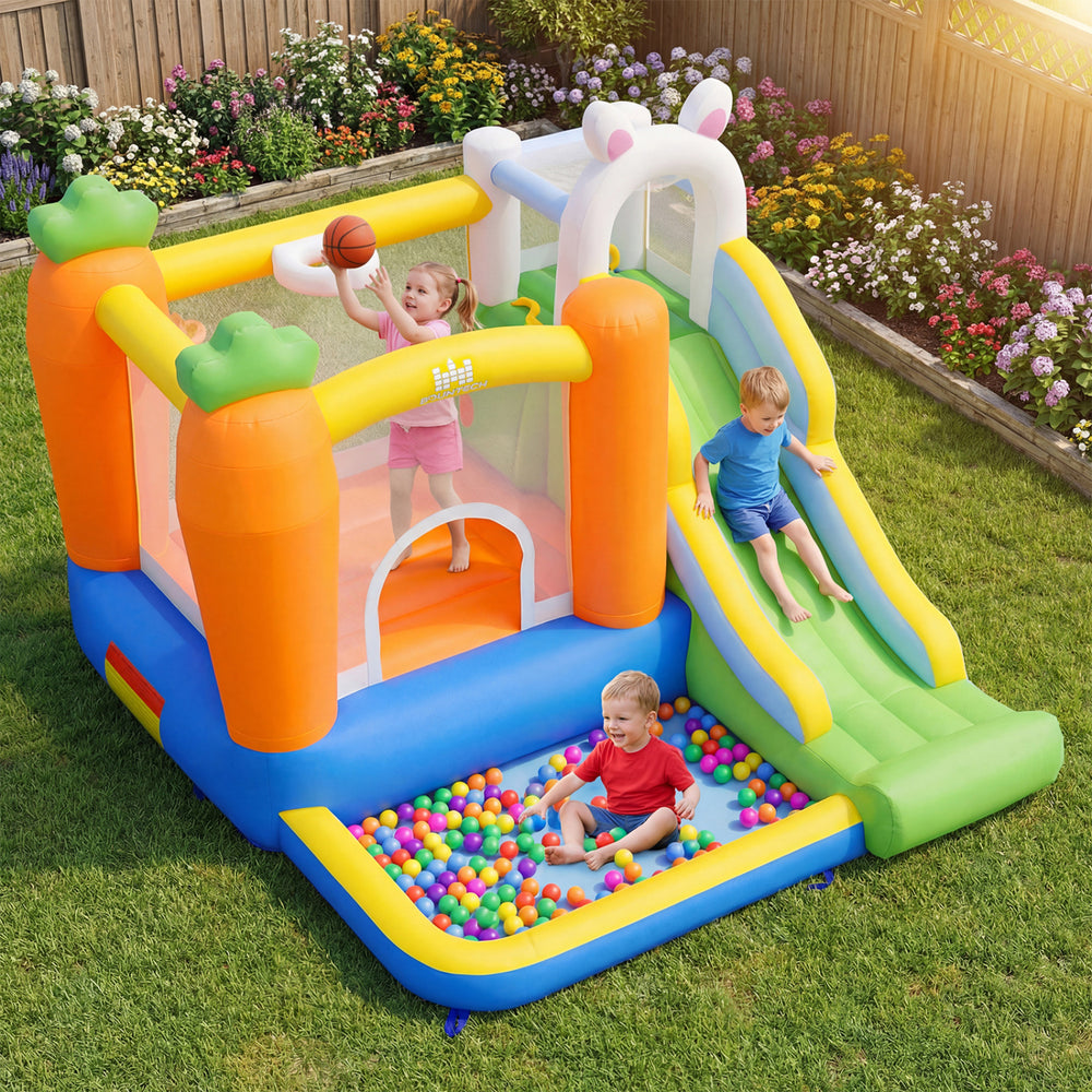 Kids enjoying the bright bounce house with a basketball rim, climbing wall, and colorful ball pit for outdoor fun.