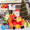 Christmas inflatable Santa Claus on a sofa with an elf and gift boxes, featuring warm white LED lights for festive charm.