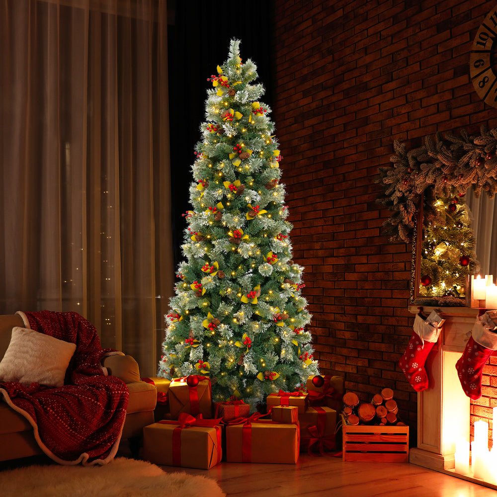 Pre-lit artificial Christmas tree with red berries and pine cones, creating a warm glow for festive home decor.