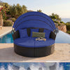 Round blue wicker patio daybed with retractable canopy and pillows, perfect for outdoor relaxation by the pool.