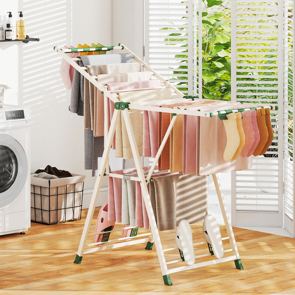 Clothes drying rack in beige with height adjustable wings, featuring 28 clips and 4 shoe holders for versatile drying.