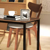 Modern dining chair with ergonomic curved back and wooden legs, paired with a sleek glass table for versatile use.