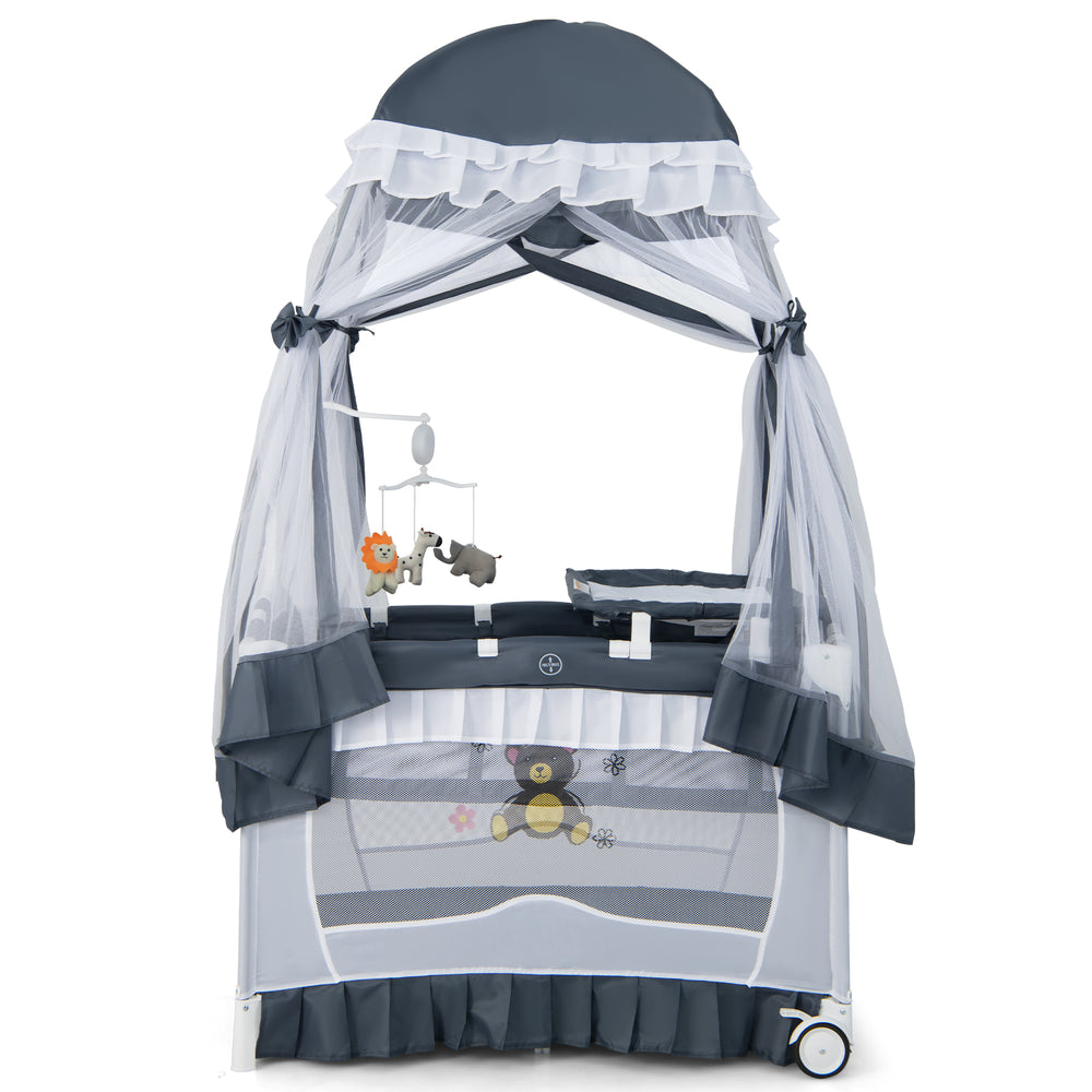 Convertible bassinet in grey with removable changing table, mesh canopy, and toys, ideal for infants up to 3 years.