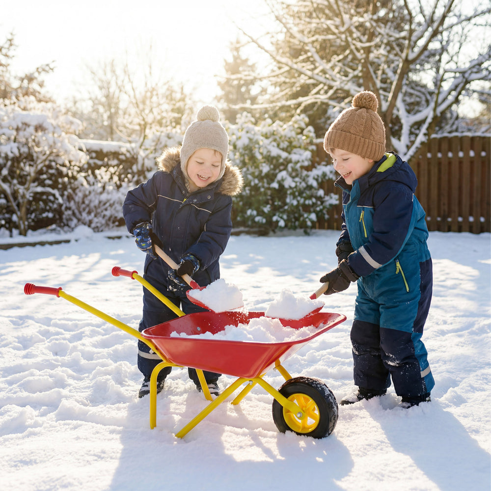 Kids using a red wheelbarrow with all-terrain wheels to play in the snow, perfect for outdoor fun and stability.