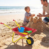 Kids wheelbarrow in red with all-terrain wheels, perfect for hauling toys and sand at the beach with a child.