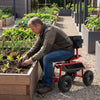Cushioned rolling garden cart scooter in black and red, featuring a storage basket, used for planting in a garden bed.