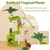 Multi-level green cat tree with artificial tropical plants, spacious condo, and sisal scratching posts for playful cats.