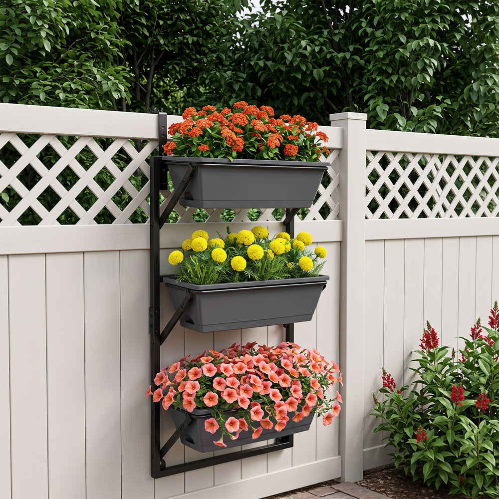 Three-tier black deck railing planter boxes with adjustable brackets, ideal for growing flowers and herbs in sunlight.