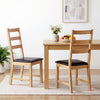 Set of 2 farmhouse dining chairs with hollowed backrest and PU leather cushions, perfect for cozy dining spaces.