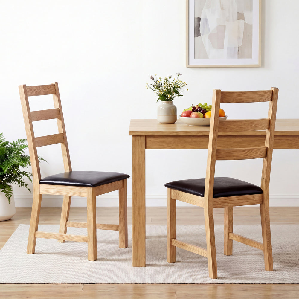 Set of 2 farmhouse dining chairs with hollowed backrest and PU leather cushions, perfect for cozy dining spaces.