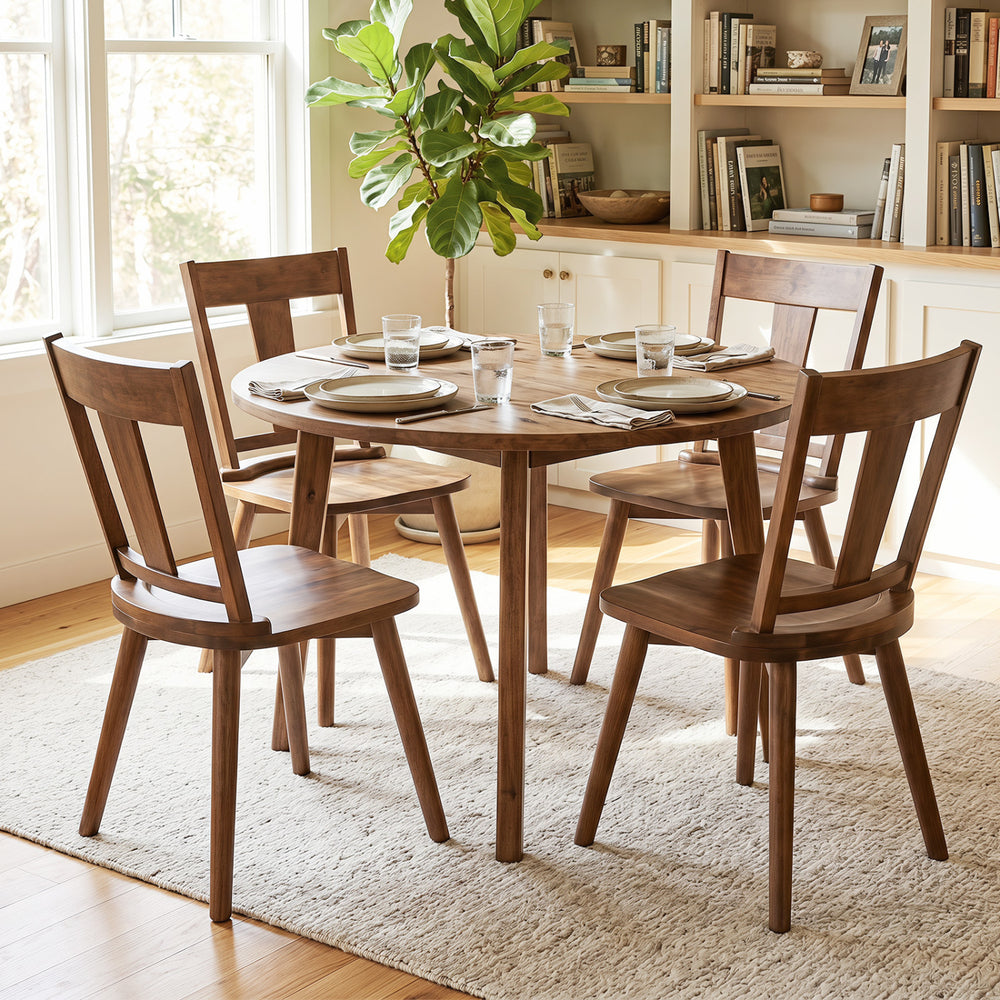 Set of four walnut dining chairs featuring ergonomic backrests and solid rubber wood frames for kitchen or dining room use.