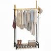 Double rods garment rack in gold and black with hanging clothes, side hooks, and bottom shelf for shoes and accessories.