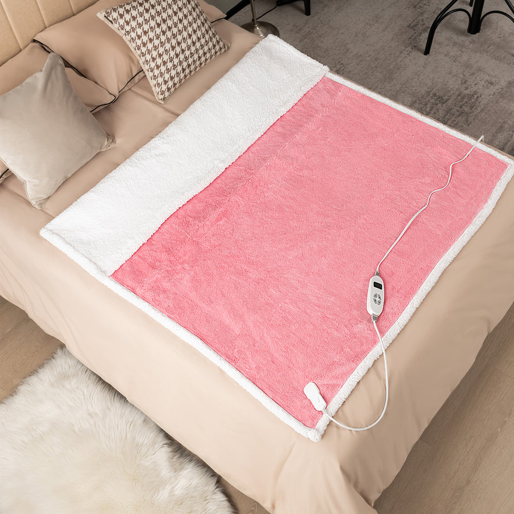 Electric heated blanket throw in pink with sherpa fleece, featuring 10 heat settings for cozy comfort on a bed.