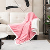 Cozy pink electric heated blanket throw draped over a sofa, featuring soft sherpa fleece for ultimate comfort.