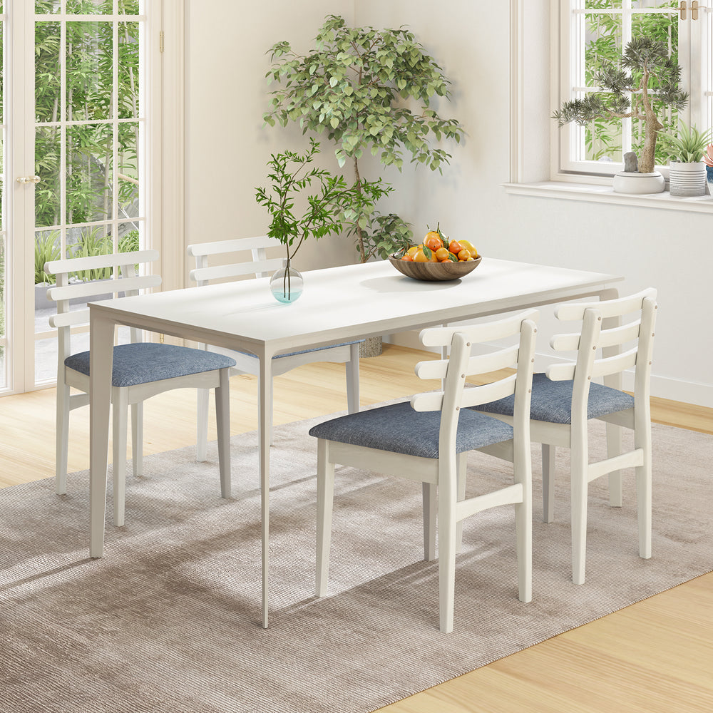 White fabric kitchen side chairs with rubber wood frame and padded seats, arranged around a dining table in a bright.