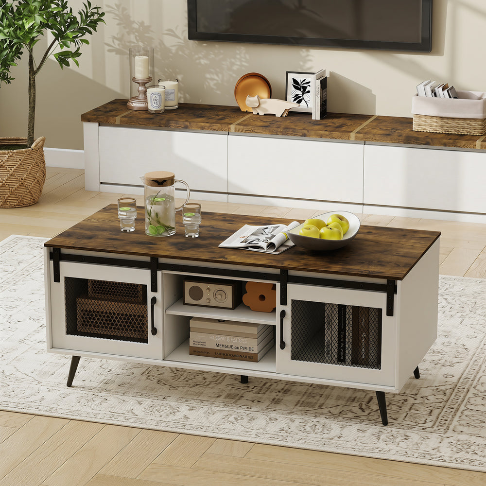 Farmhouse coffee table with rustic brown top, sliding doors, and adjustable shelf for versatile storage in any living.