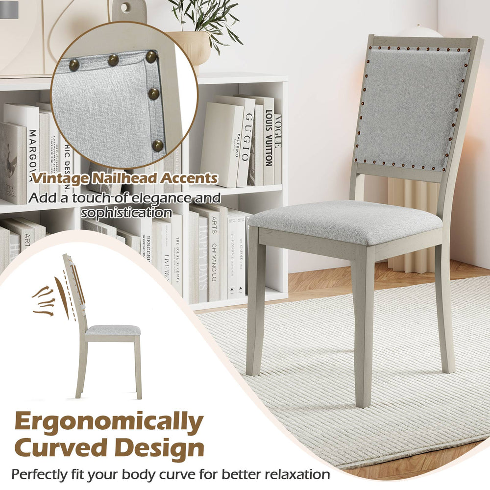 Farmhouse dining chair with grey fabric upholstery and vintage nailhead accents, ergonomically curved for comfort.
