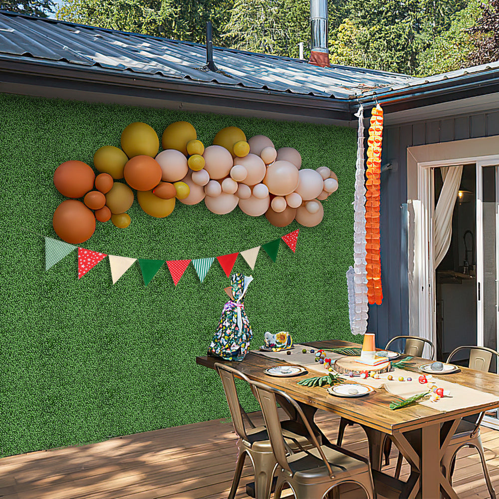 Artificial boxwood wall panels with vibrant balloons and bunting, perfect for outdoor party decoration and easy to.