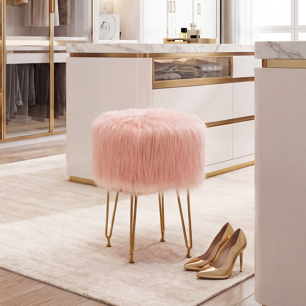 Pink faux fur vanity stool with gold metal legs, perfect for bedroom or living room decor and compact storage.