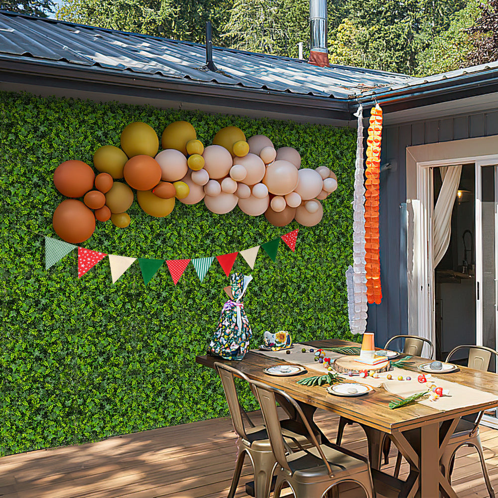 Artificial greenery foliage panels displayed on a wall, featuring 6 plant types for customizable outdoor decor.