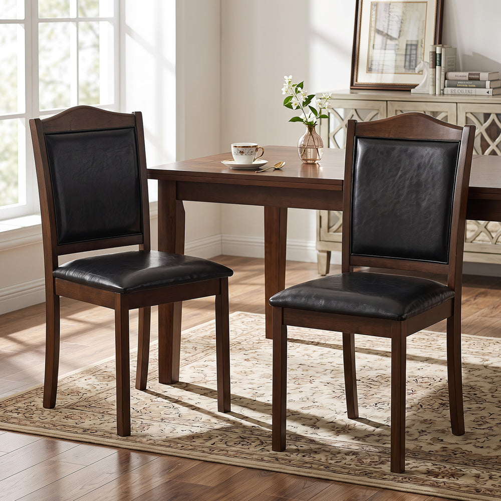 Set of two walnut farmhouse dining chairs featuring faux leather upholstery and sturdy rubber wood frames for comfort.
