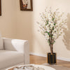 Faux plum blossom plant with white fabric flowers and solid wood trunk in a black pot, perfect for elegant home decor.