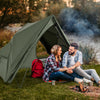 Foldable 2-person camping cot tent in green, set up by a lake, perfect for outdoor adventures and camping trips.